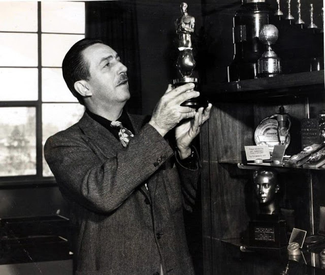 Foto de Walt Disney em seu escritório em Hollywood segurando uma estátua do Oscar, 1949 (Popperfoto)