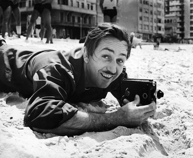 Foto de Walt Disney na praia de Copacabana com uma filmadora 8mm, Rio de Janeiro, 1941. (Hart Preston)